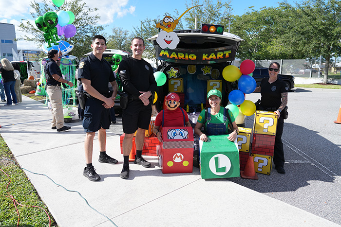 Orlando Police Officers stand posed with a Mario Kart-themed vehicle.