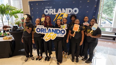 City residents posing with an Orlando 150 sign.