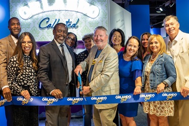 Mayor Dyer cutting an Orlando 150 ribbon.