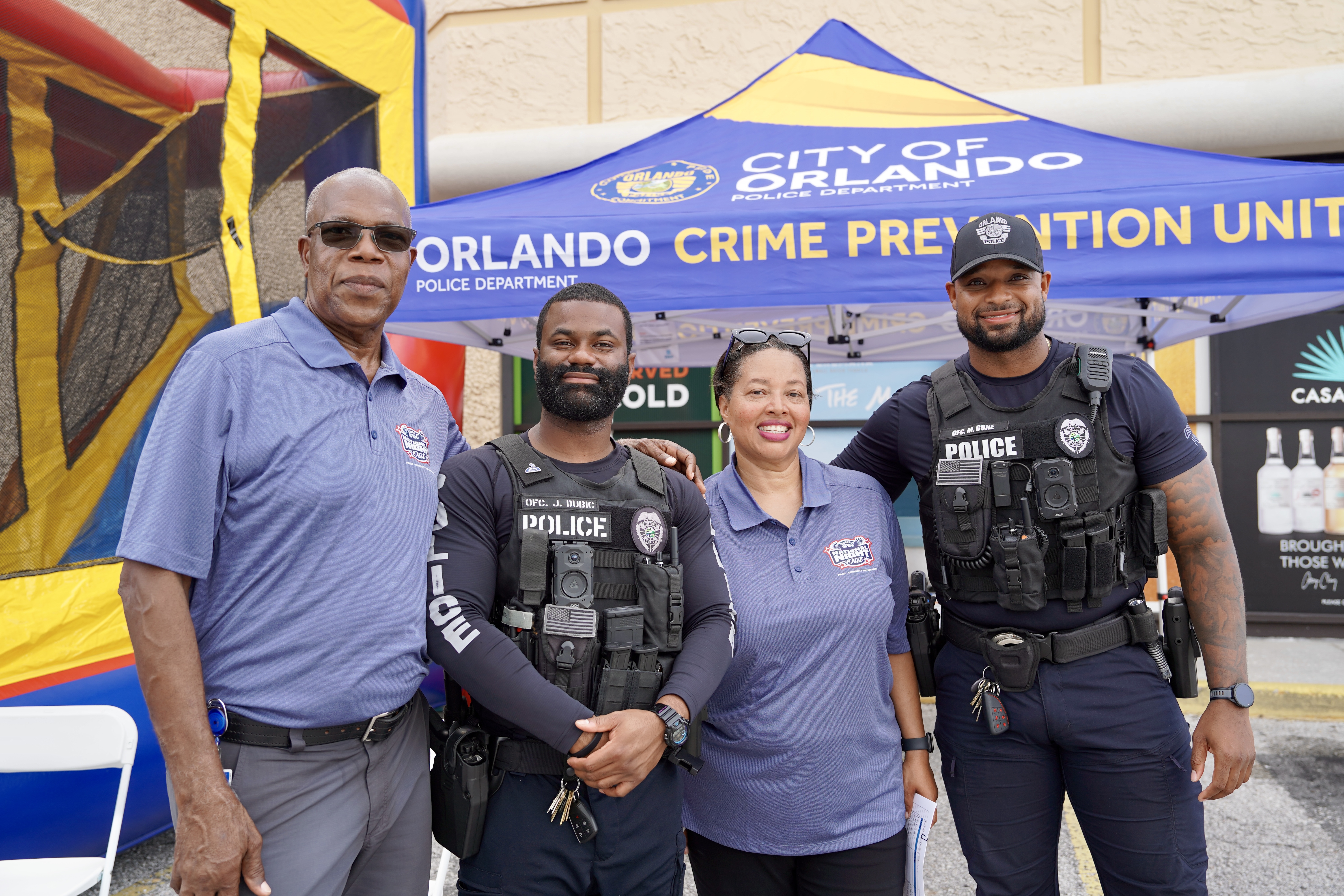 a group of people standing for a photo with two police officers standing in front of a booth that says city of orlando 