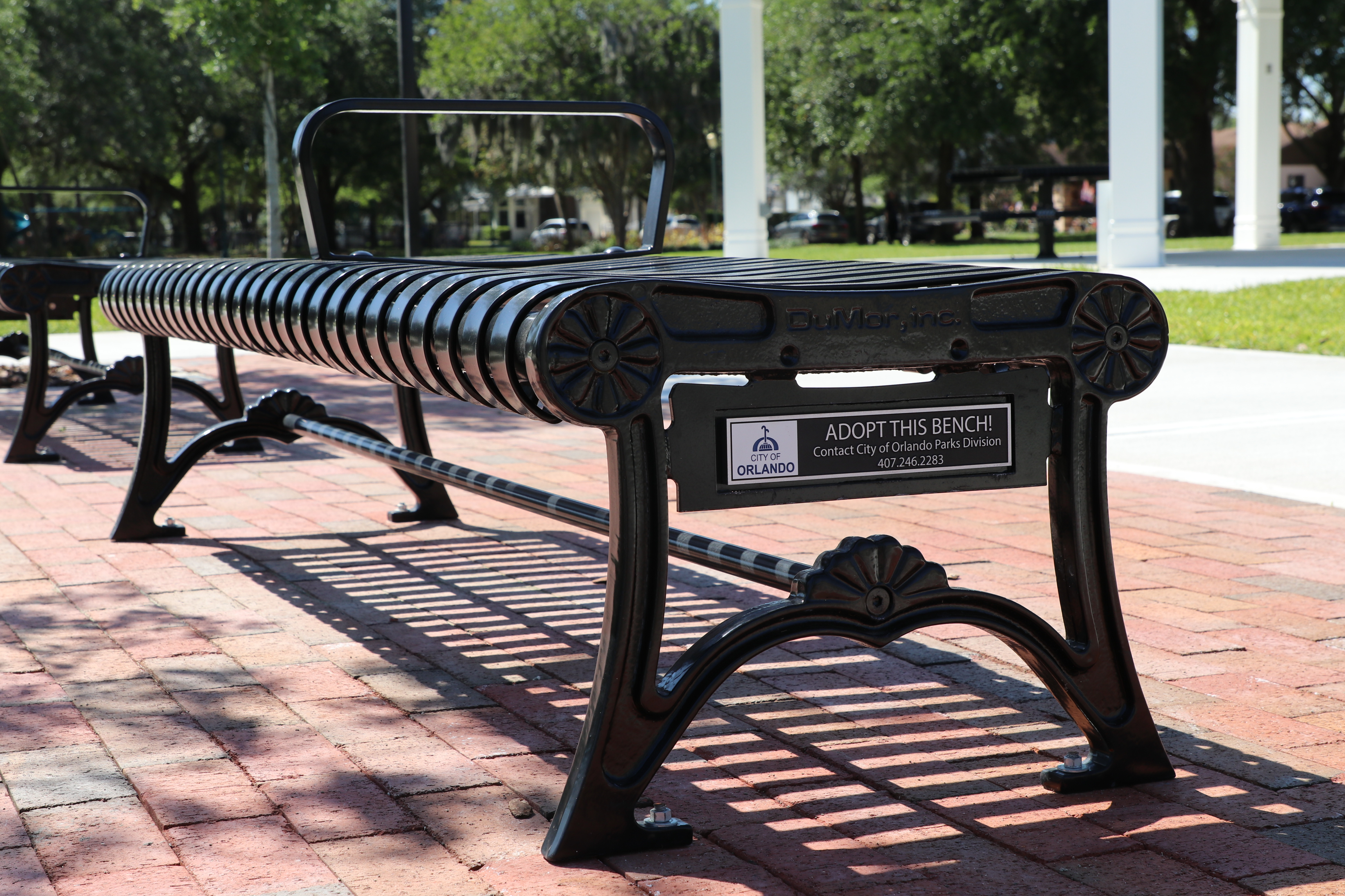 A backless bench with a commemoration plaque at a city park