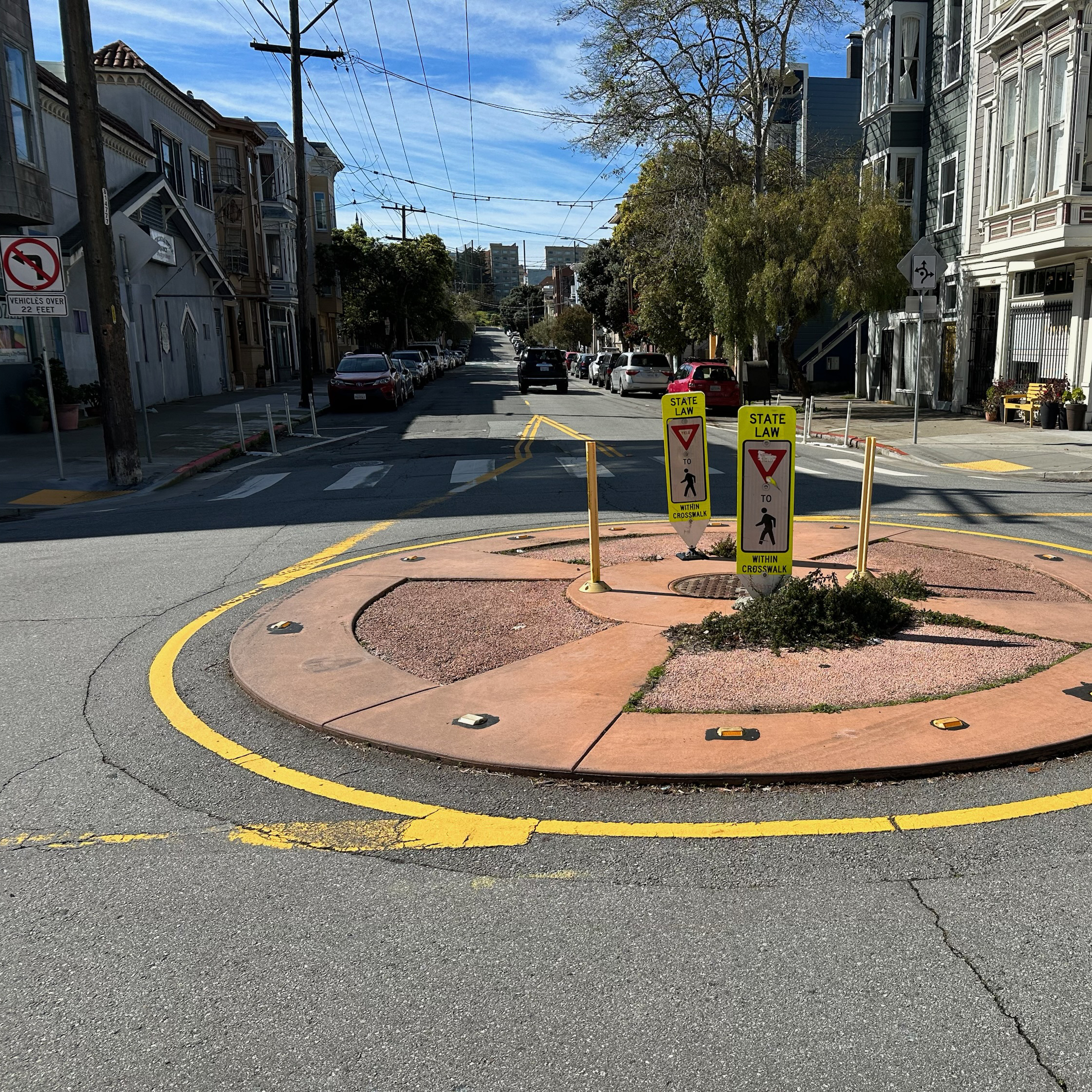 A photo of a quick-build roundabout with flex posts and signs in the middle.