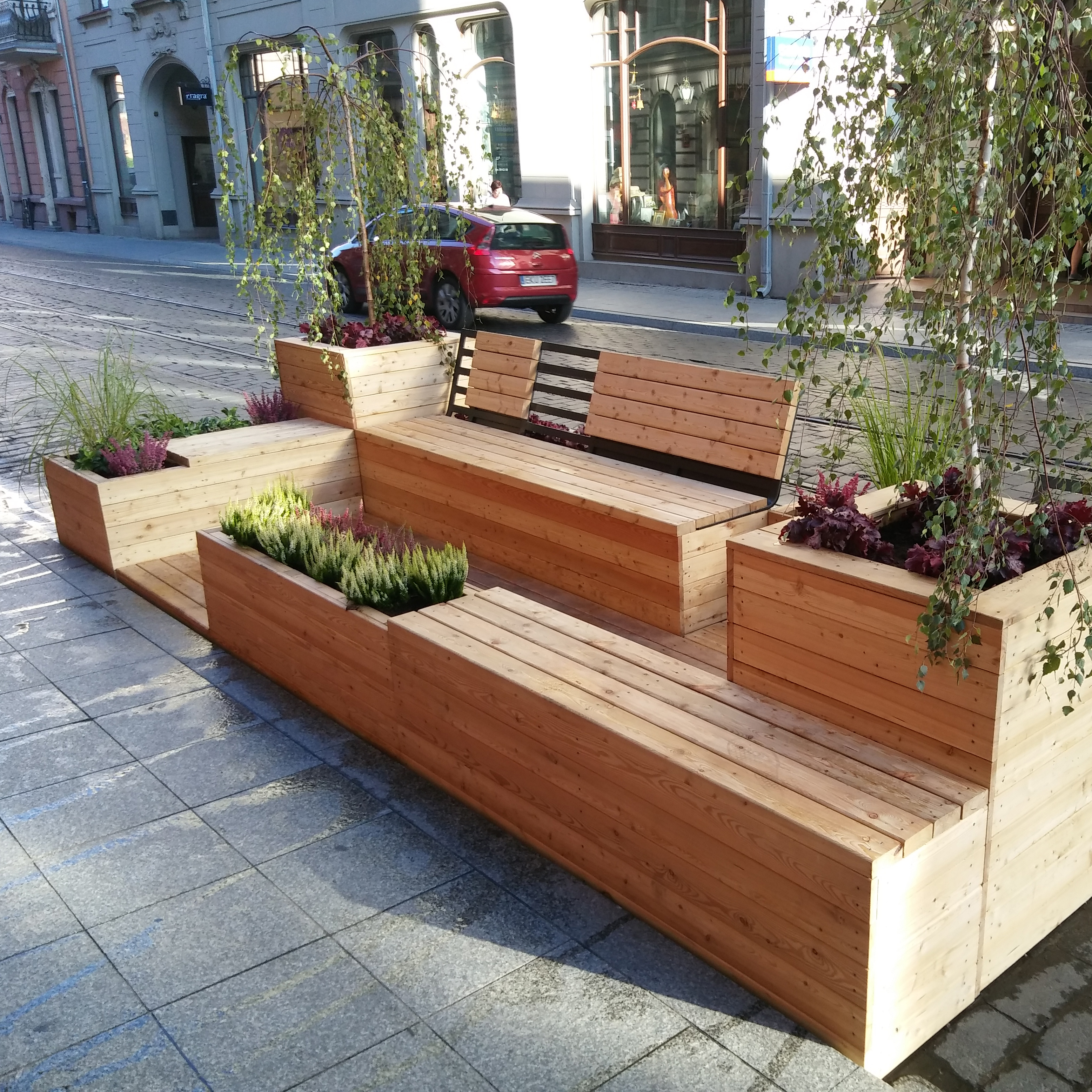 A photo of a parklet consisting of wooden benches and planters.