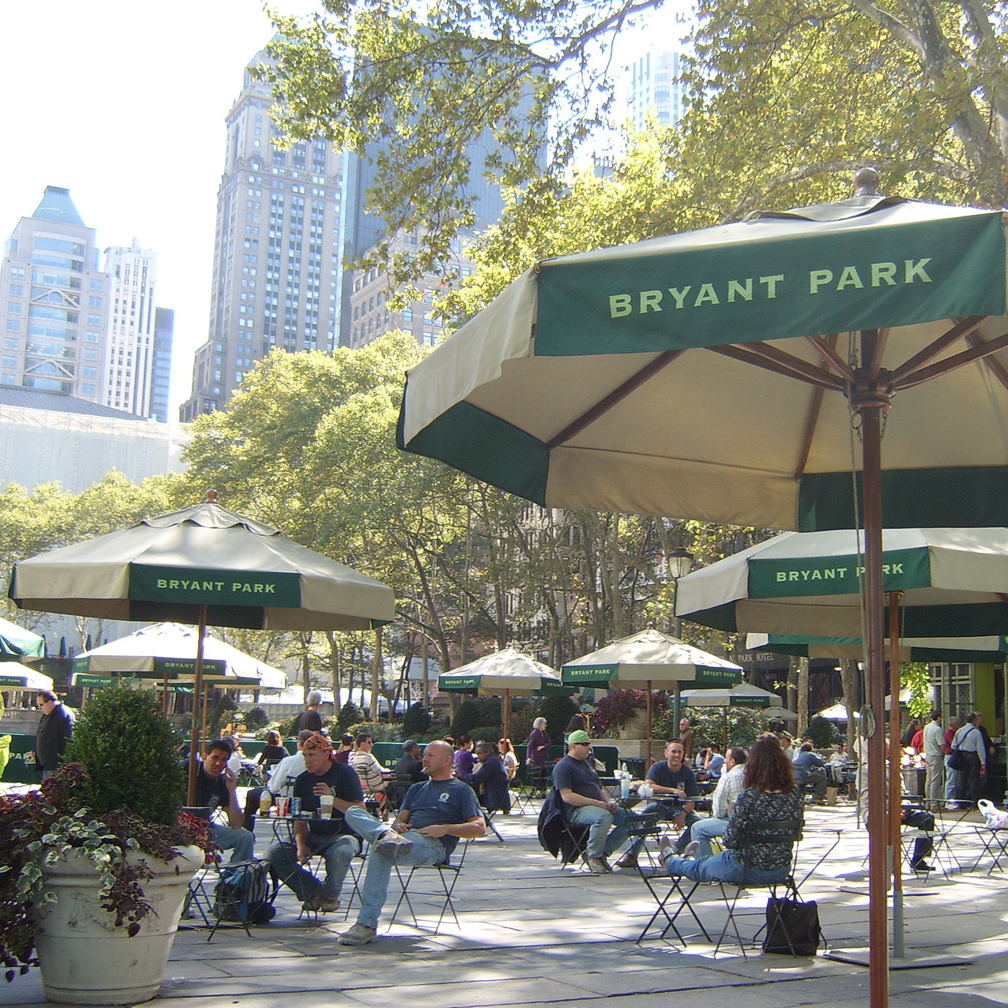 A photograph of street furniture and umbrellas in Bryant Park in New York City.