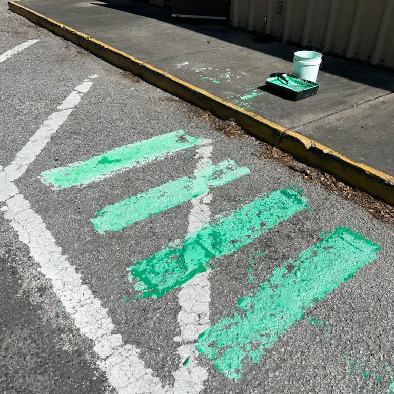 A photograph of a roadway with green bicycle conflict markings painted with cornstarch paint.