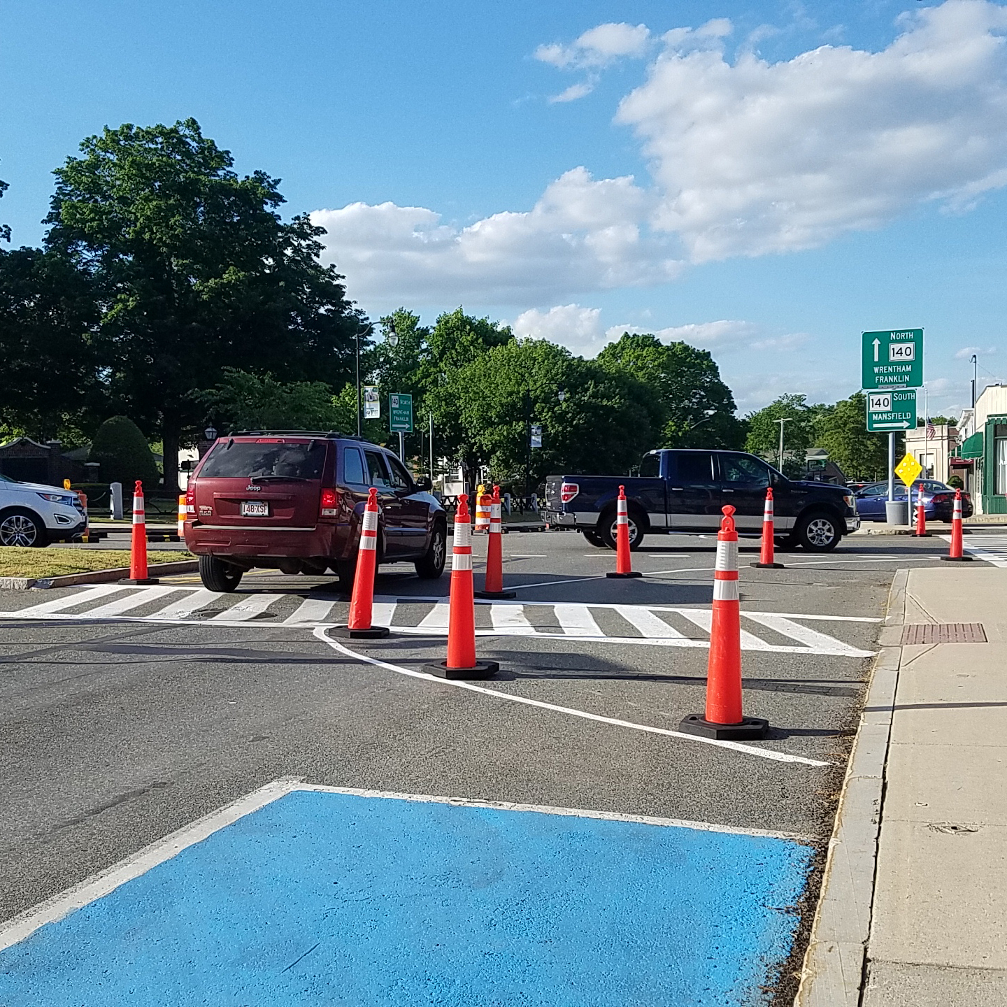 Orange vertical delineators line the temporary curb extension and help direct traffic.