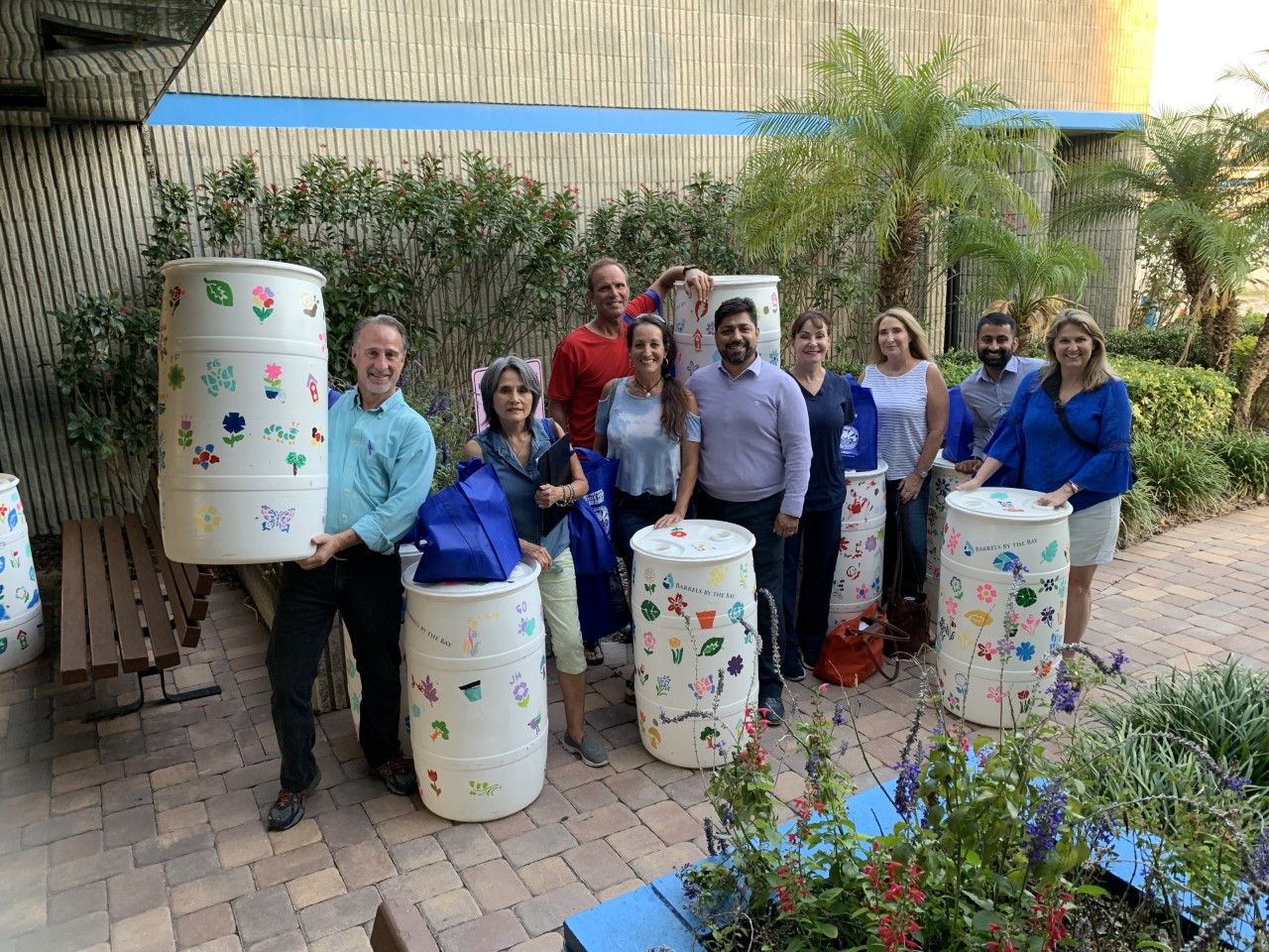 Workshop attendees posing with their decorated rain barrel